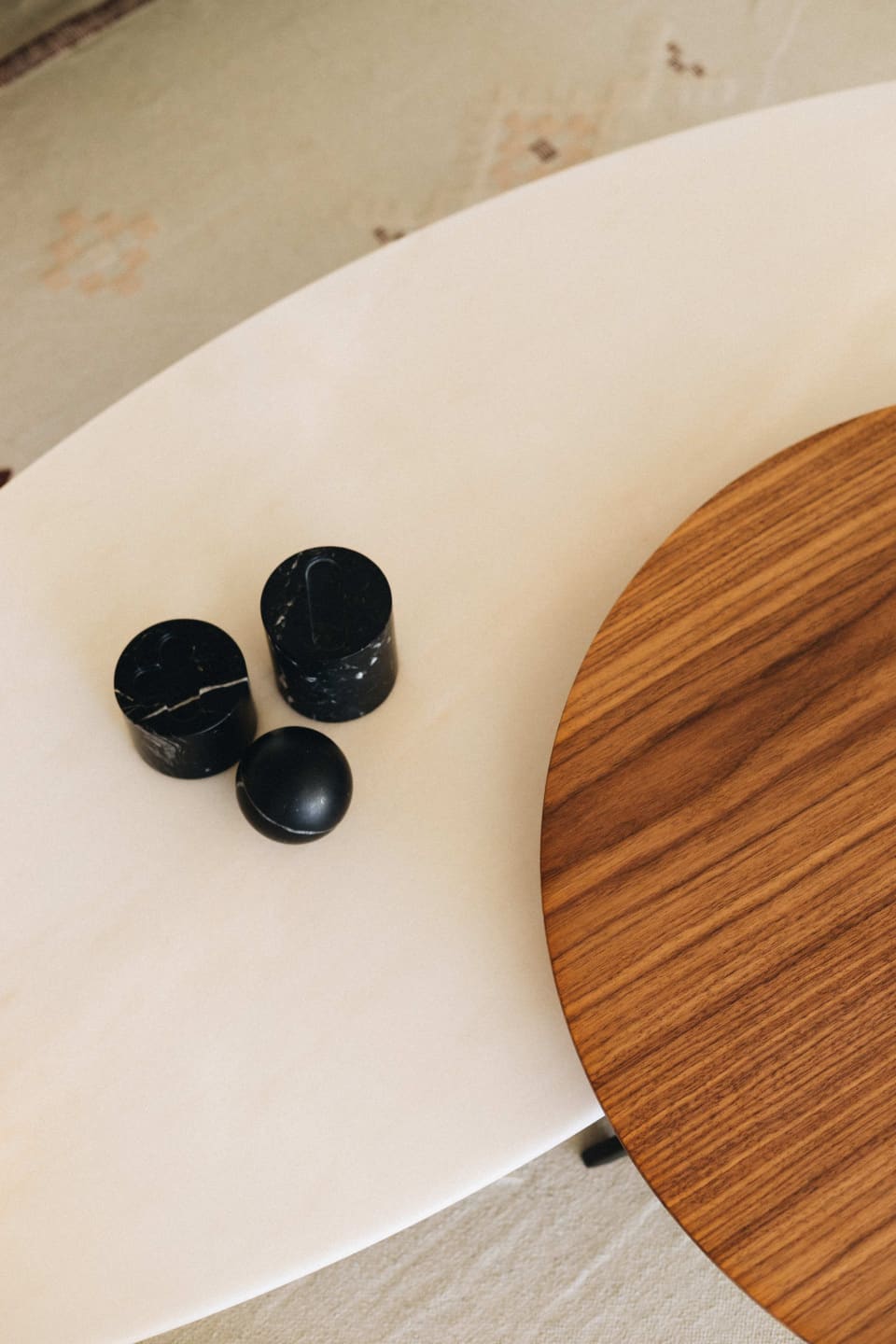 Polished white marble coffee table with a walnut top and three black marble objects